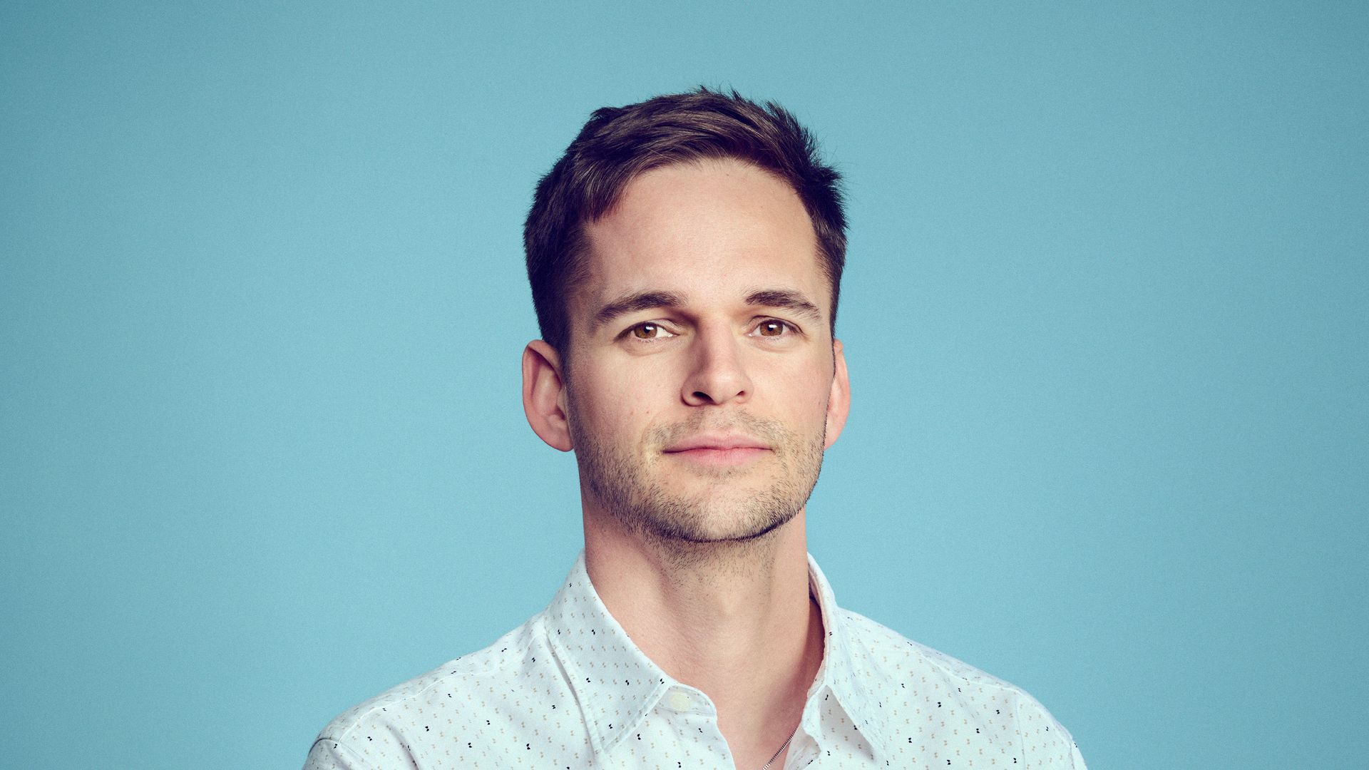 Smart man with his arms crossed wearing an untucked shirt