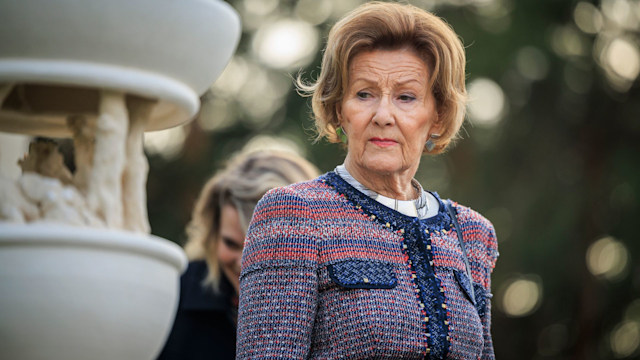 Queen Sonja next to a stone fountain