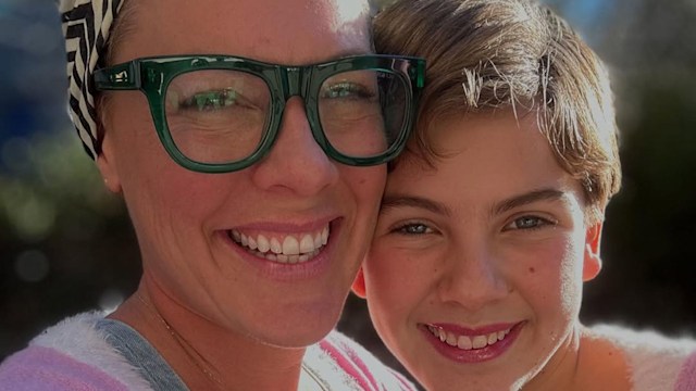 Pink wearing black top, dungarees and pink cardigan smiles as she takes selfie with her daughter Willow wearing same pink cardigan
