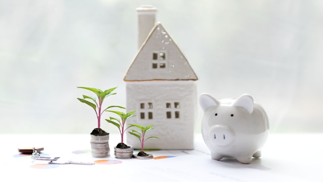 Model wood house and piggy saving with safety key for the investment of real estate