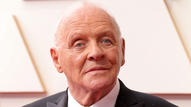 Anthony Hopkins dress in a suit looking at cameras while walking red carpet at the Oscars in 2022