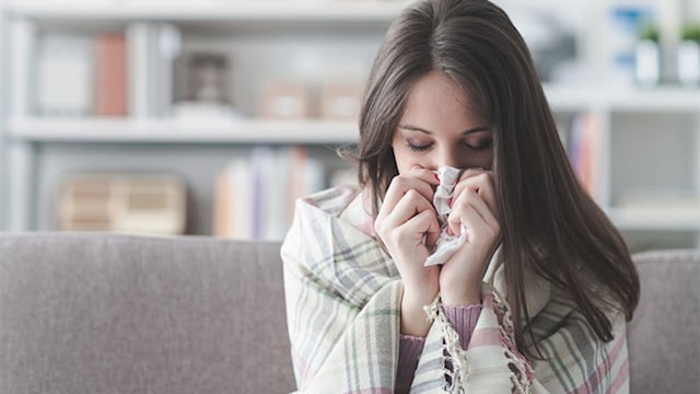 woman blowing nose cold