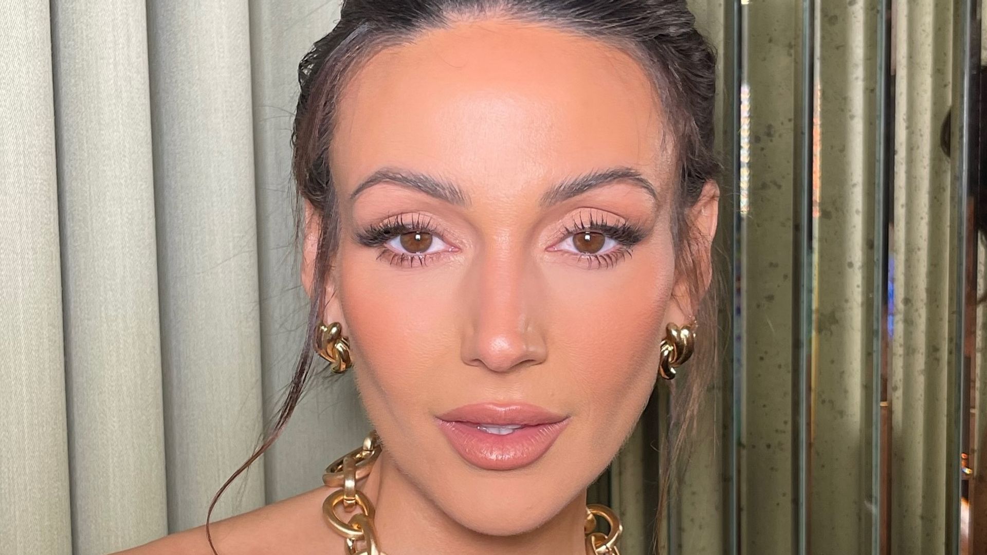 Michelle Keegan up close with her hair up, weraing gold jewellery