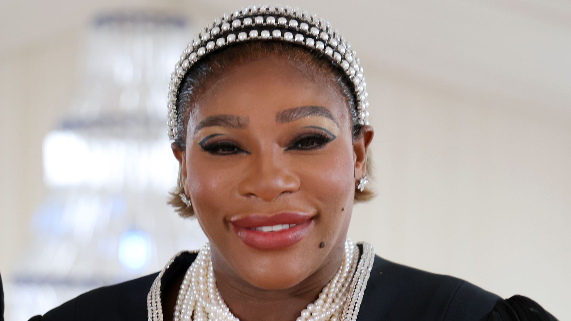 Serena Williams in a sleer-sleeved gown and pearl necklaces