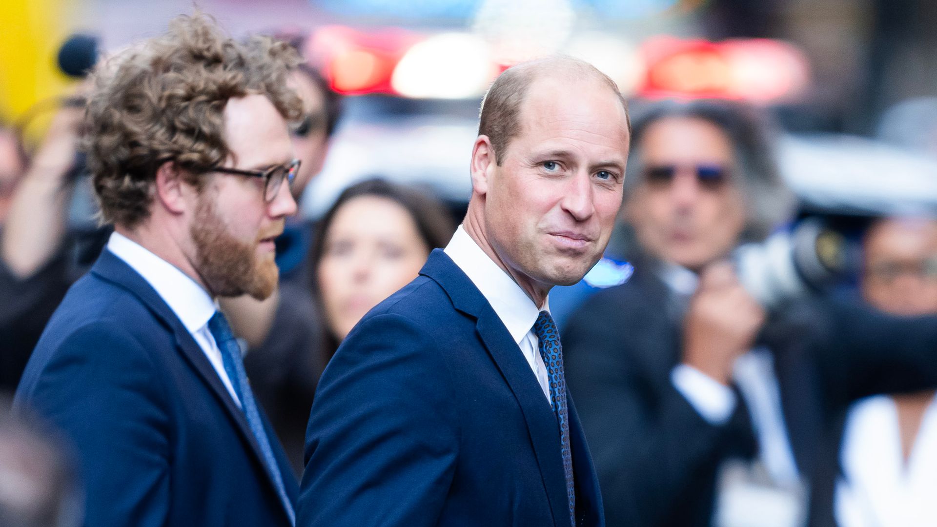 Prince William in a suit walking ahead of visiting Ladder 10 Firehouse in Tribeca 