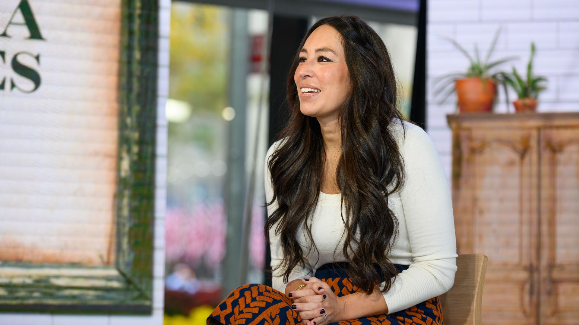 Joanna Gaines in a white top and patterned skirt
