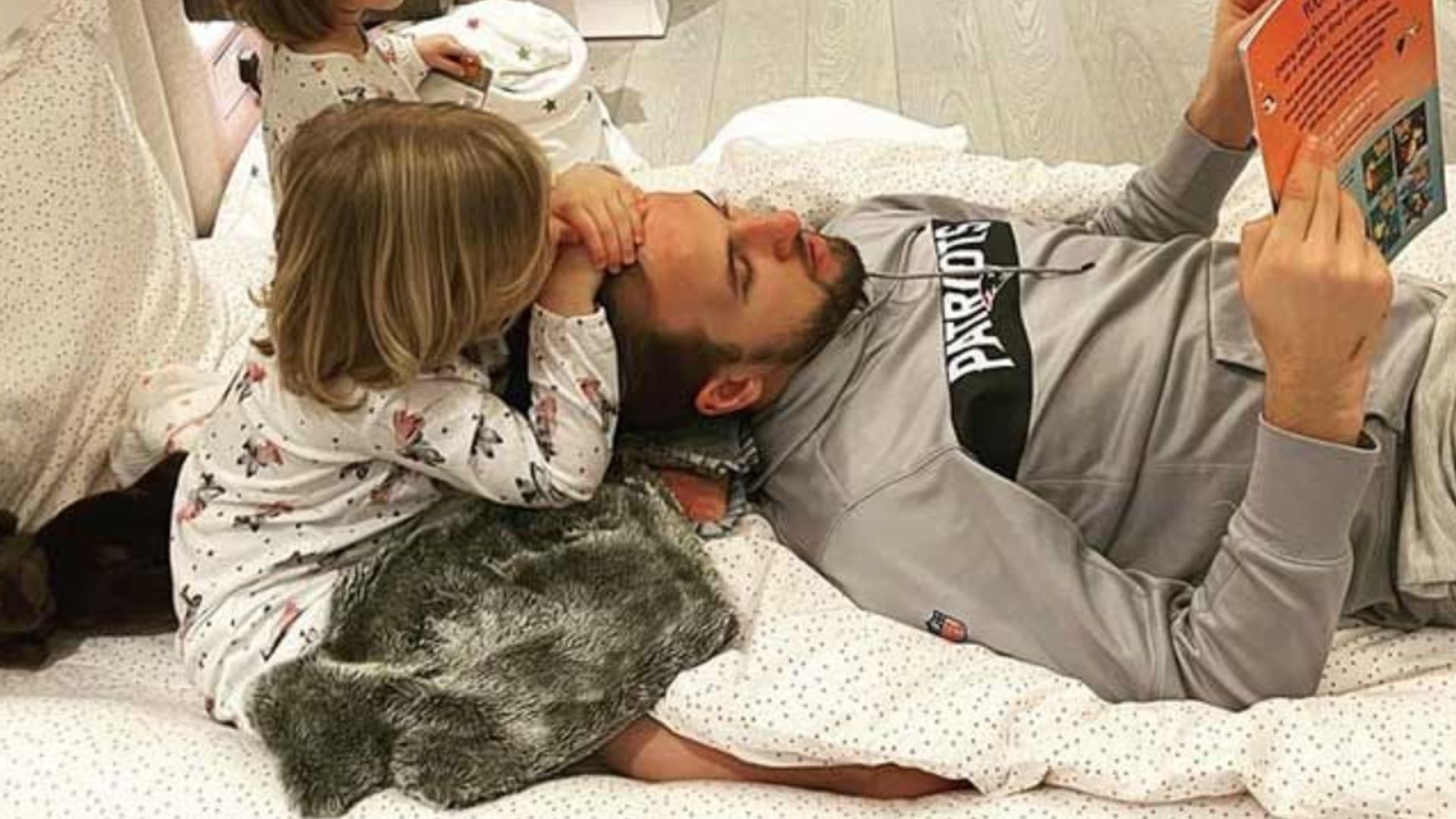 Harry Kane reading a book to two young children