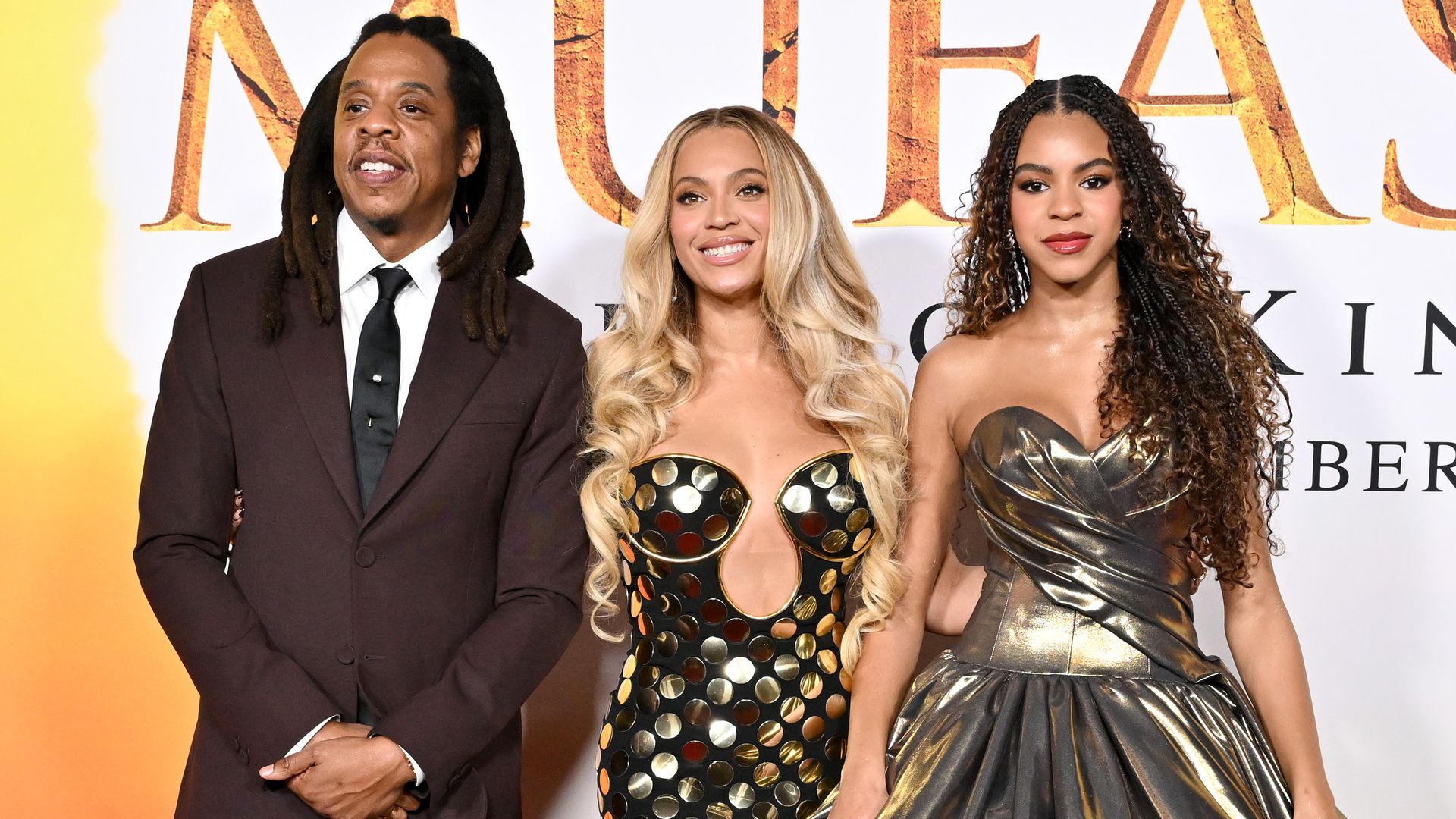 Jay-Z, Beyonce and Blue Ivy Carter standing together on the red carpet at the Mufasa Lion King