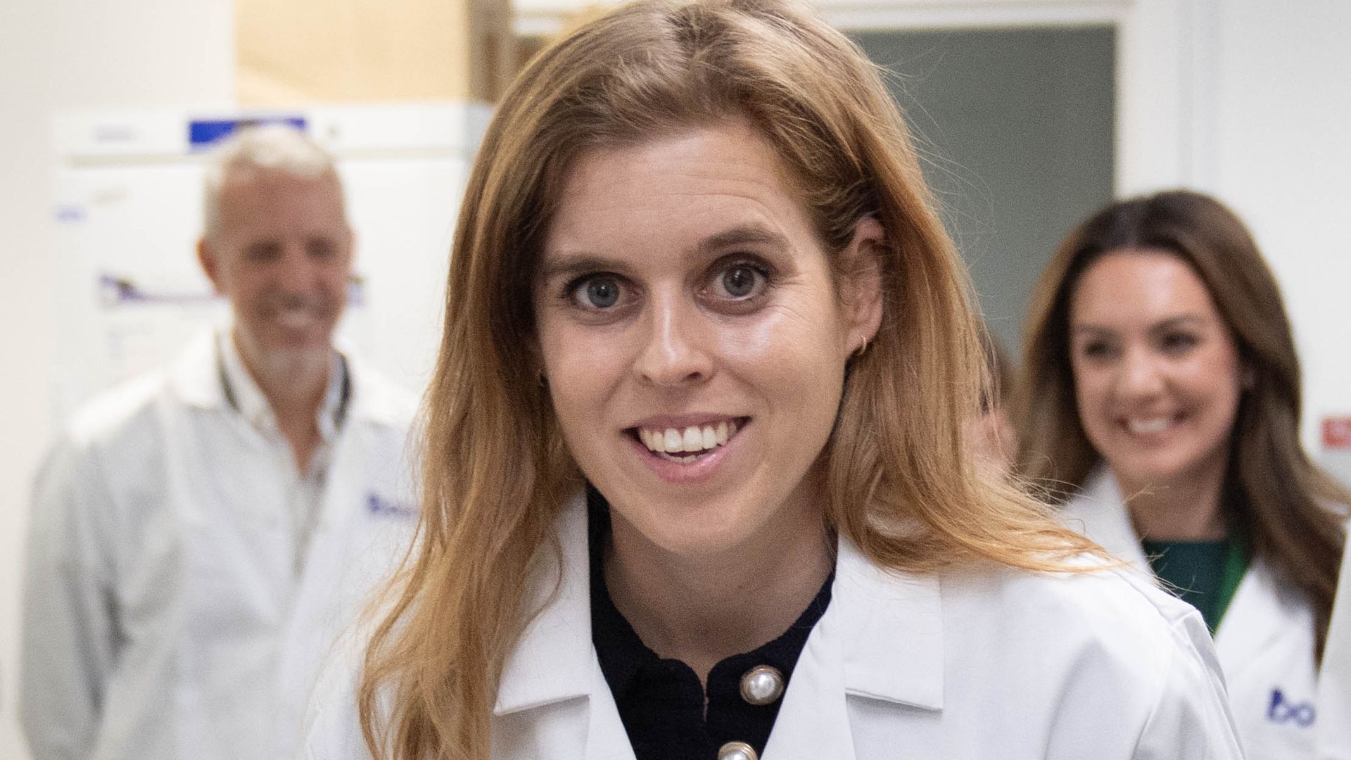 Princess Beatrice smiling in lab coat