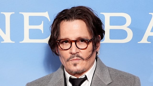 johnny depp posing in grey coat at premiere 