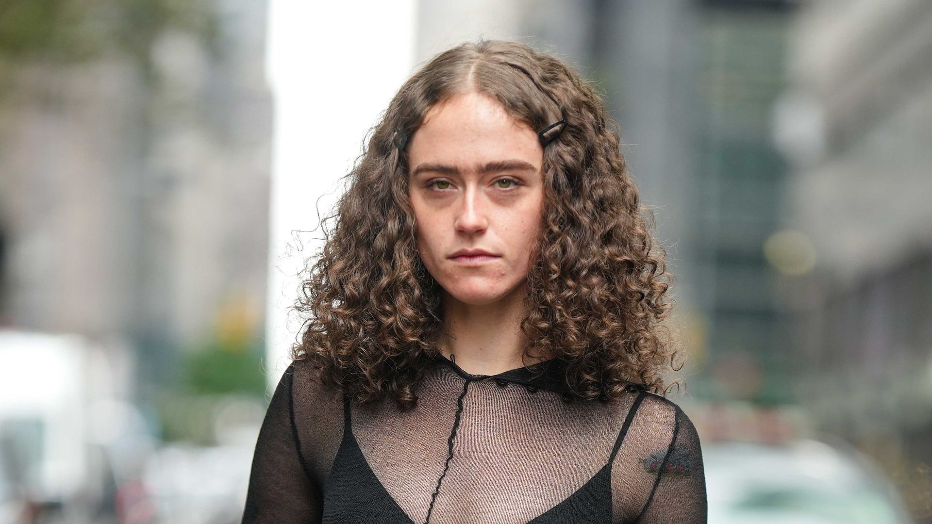 Ella Emhoff wears black bras, a black mesh top, gray suit flared pants, a black leather bag, outside Proenza Schouler, during New York Fashion Week, on September 09, 2023 in New York City.