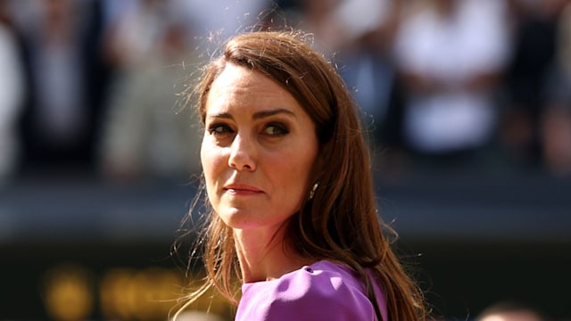 Princess Kate looking over her shoulder while wearing a purple dress