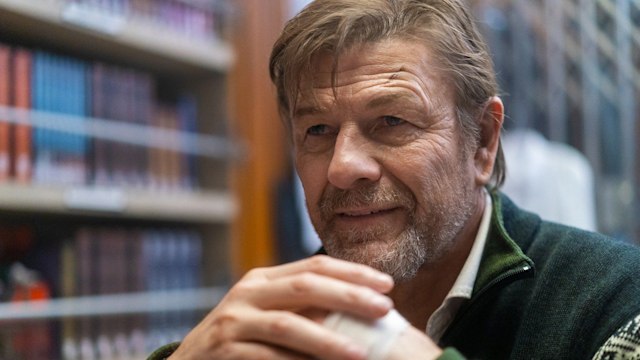 Close-up of man in library wearing green jacket
