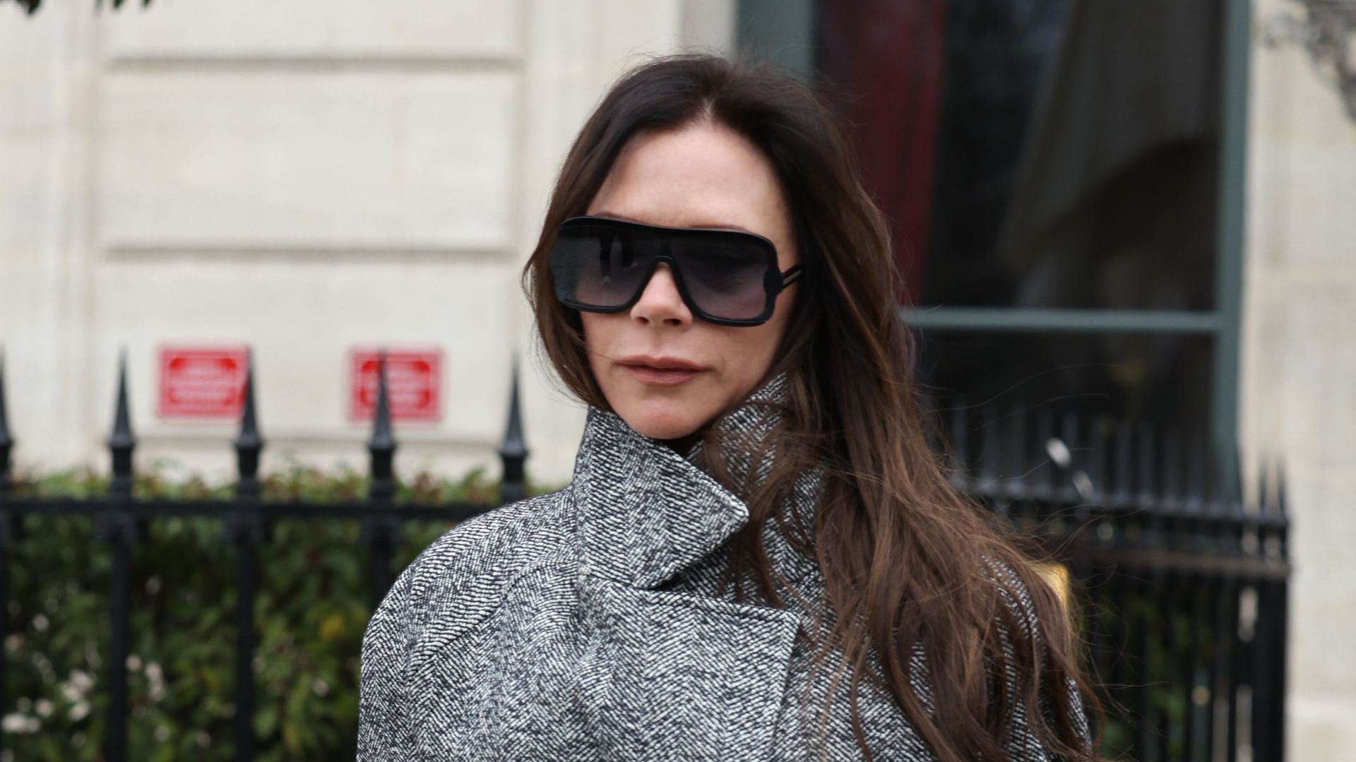 Victoria Beckham wearing sunglasses and a grey coat 