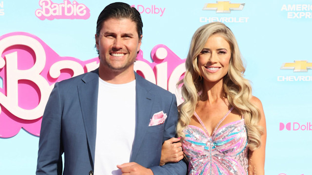 Christina and her husband Josh smiling arm in arm at the premiere