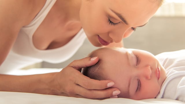 Mum smells her baby who sleeps