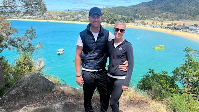 Jesse Campbell and Georgie Campbell smiling in front of a lake