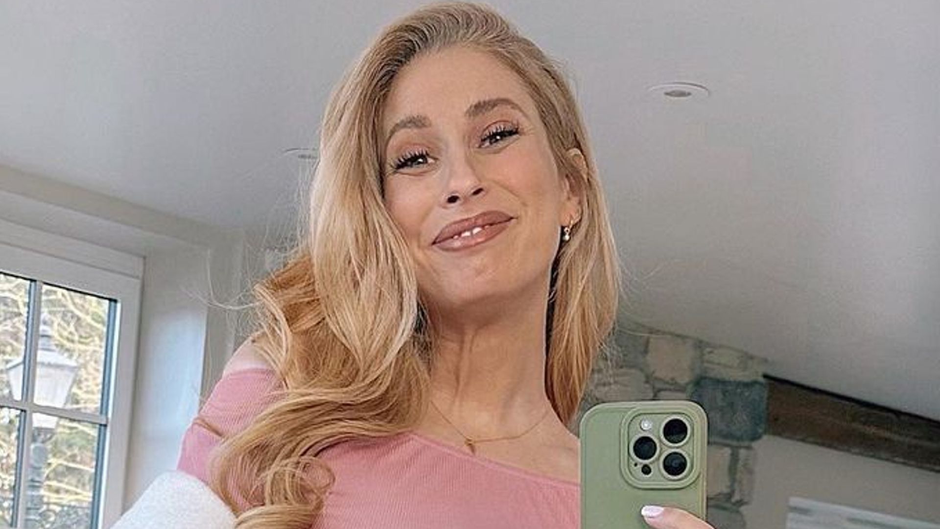 Stacey Solomon posing in pink dress with blonde hair taking mirror selfie