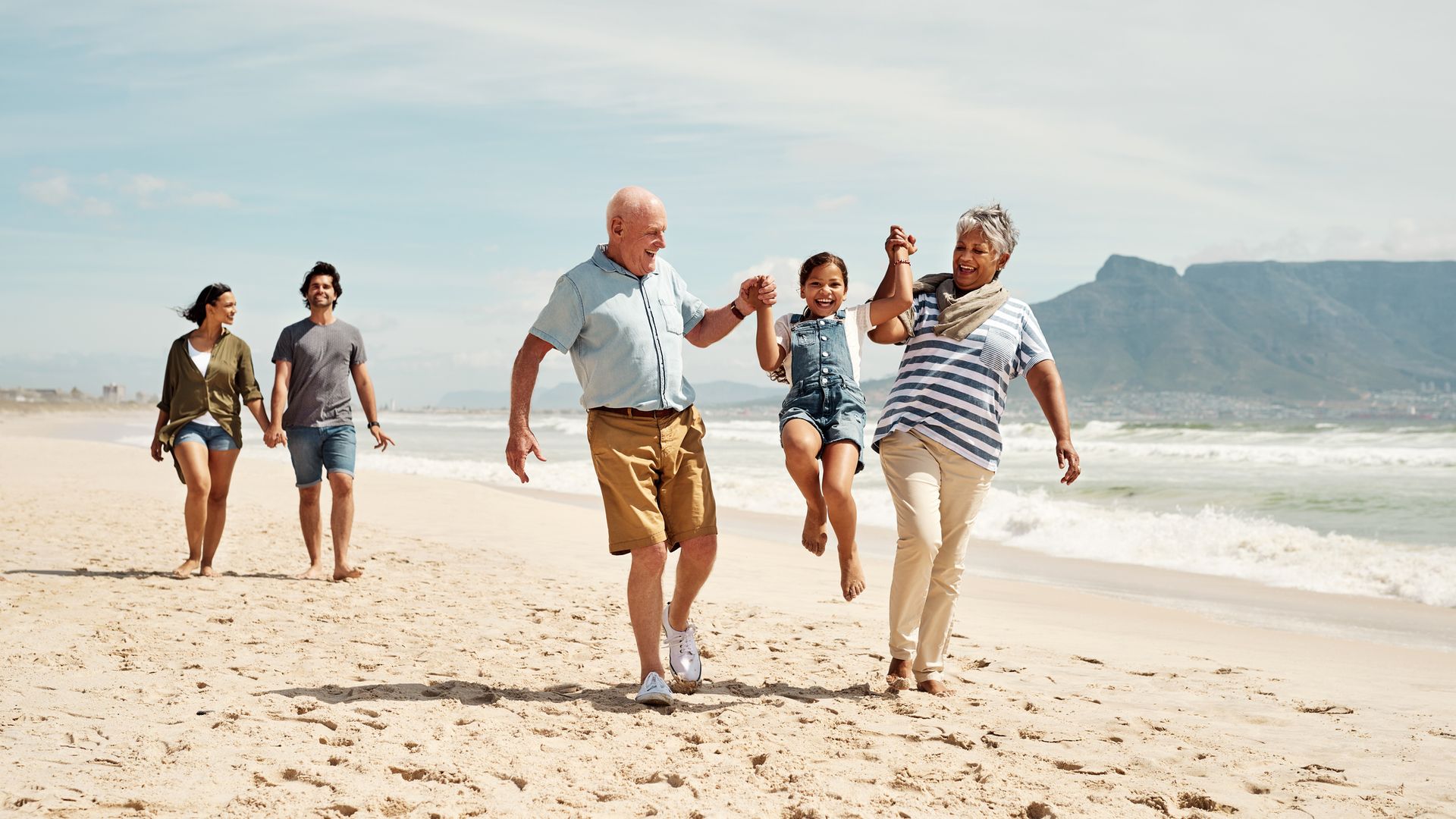 Shot of an adorable little girl having a fun day at the beach with her parents and grandparents
