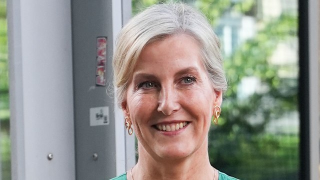 The Duchess of Edinburgh smiles in green dress holding sunflowers