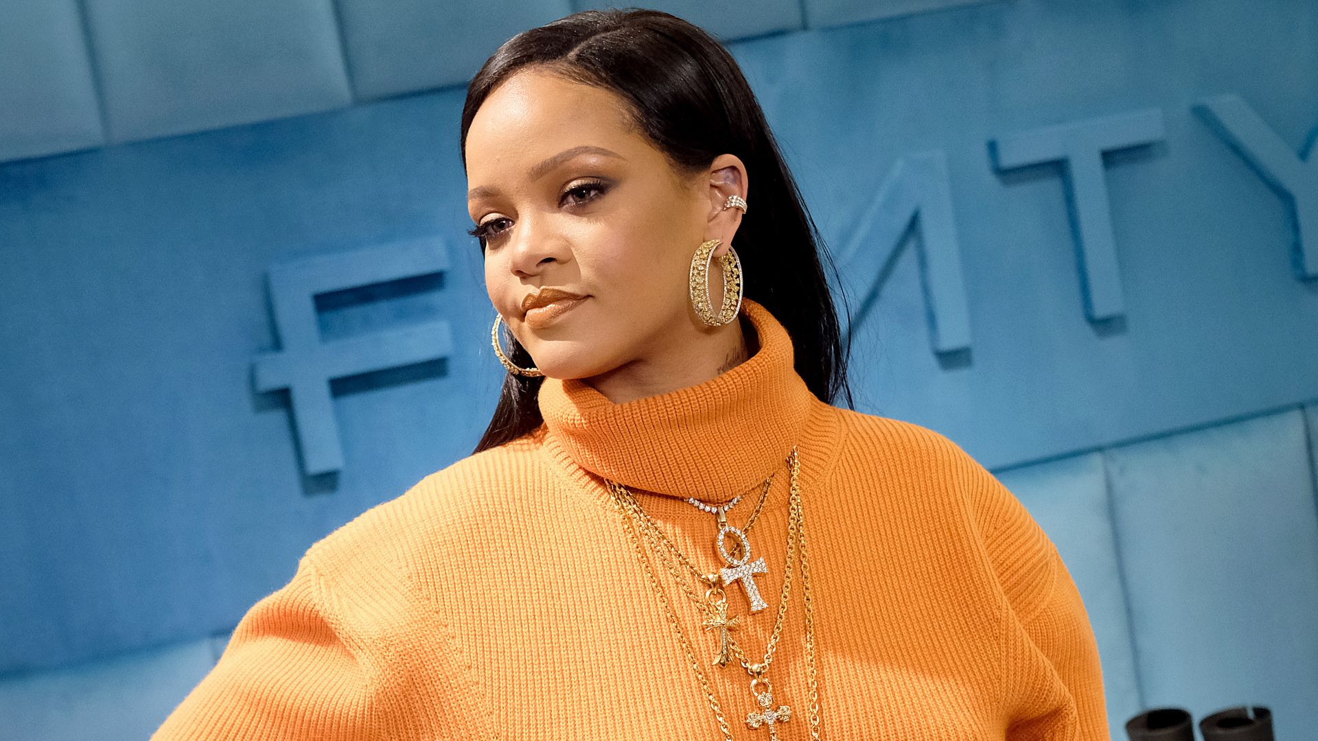 rihanna in bright orange turtleneck jumper