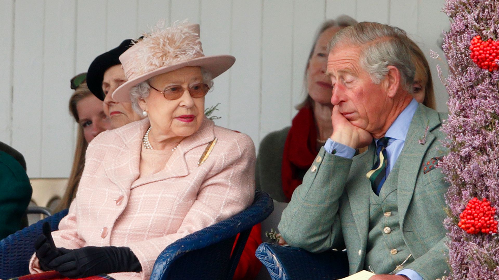queen sitting in chair next to Prince Charles
