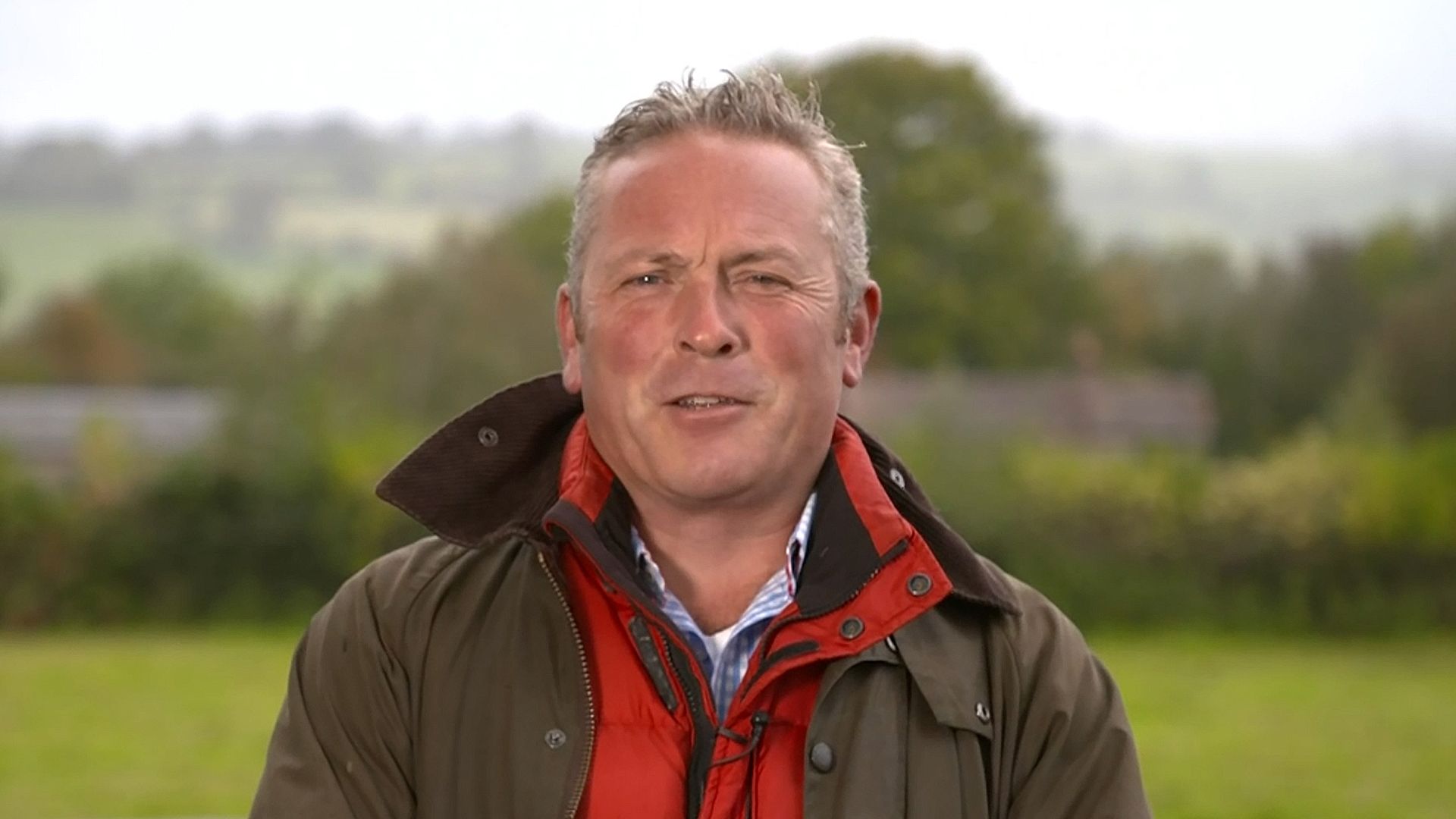 Jules Hudson speaking in a field