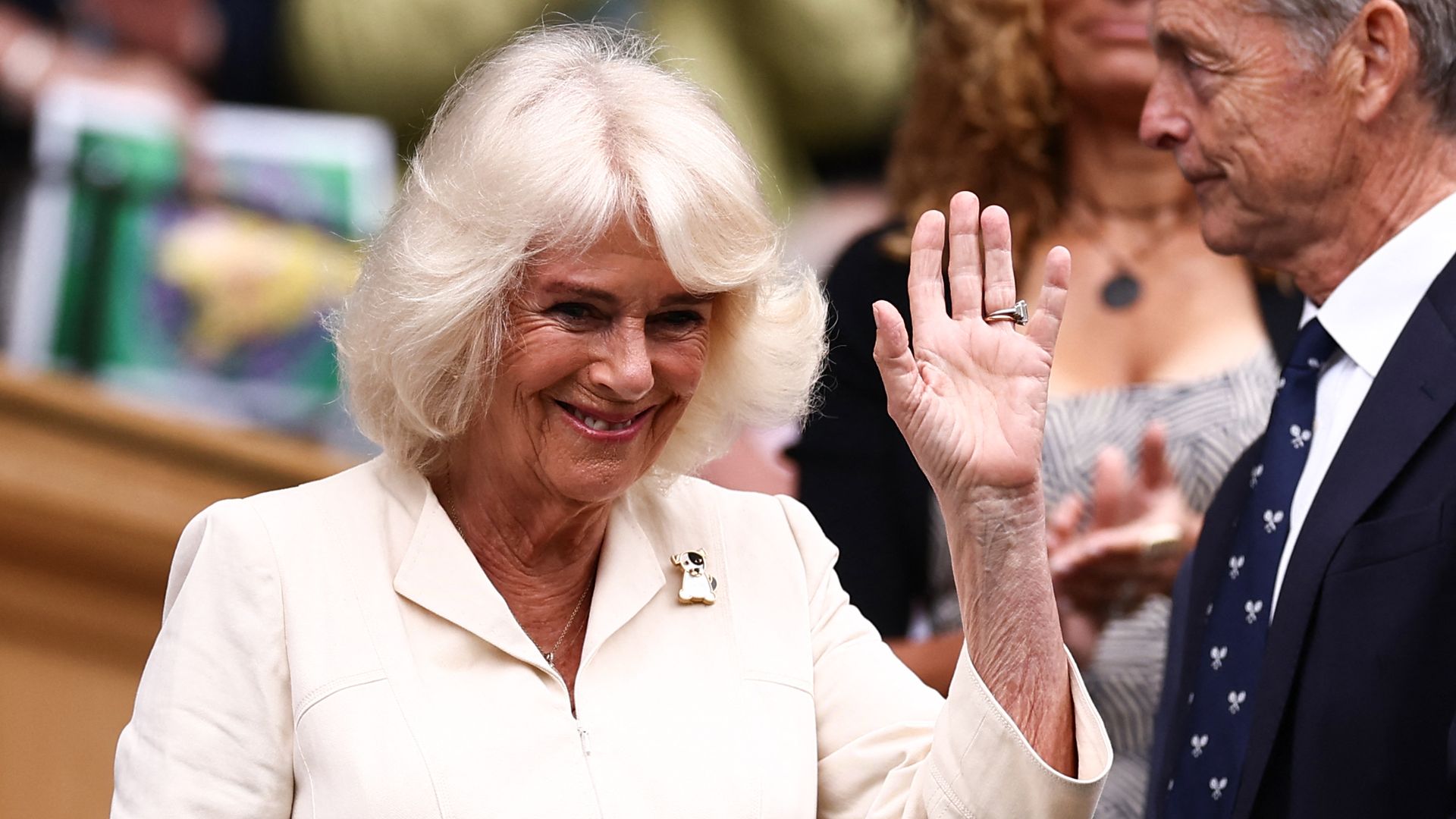 Queen Camilla waves as she arrives in the royal box at Wimbledon