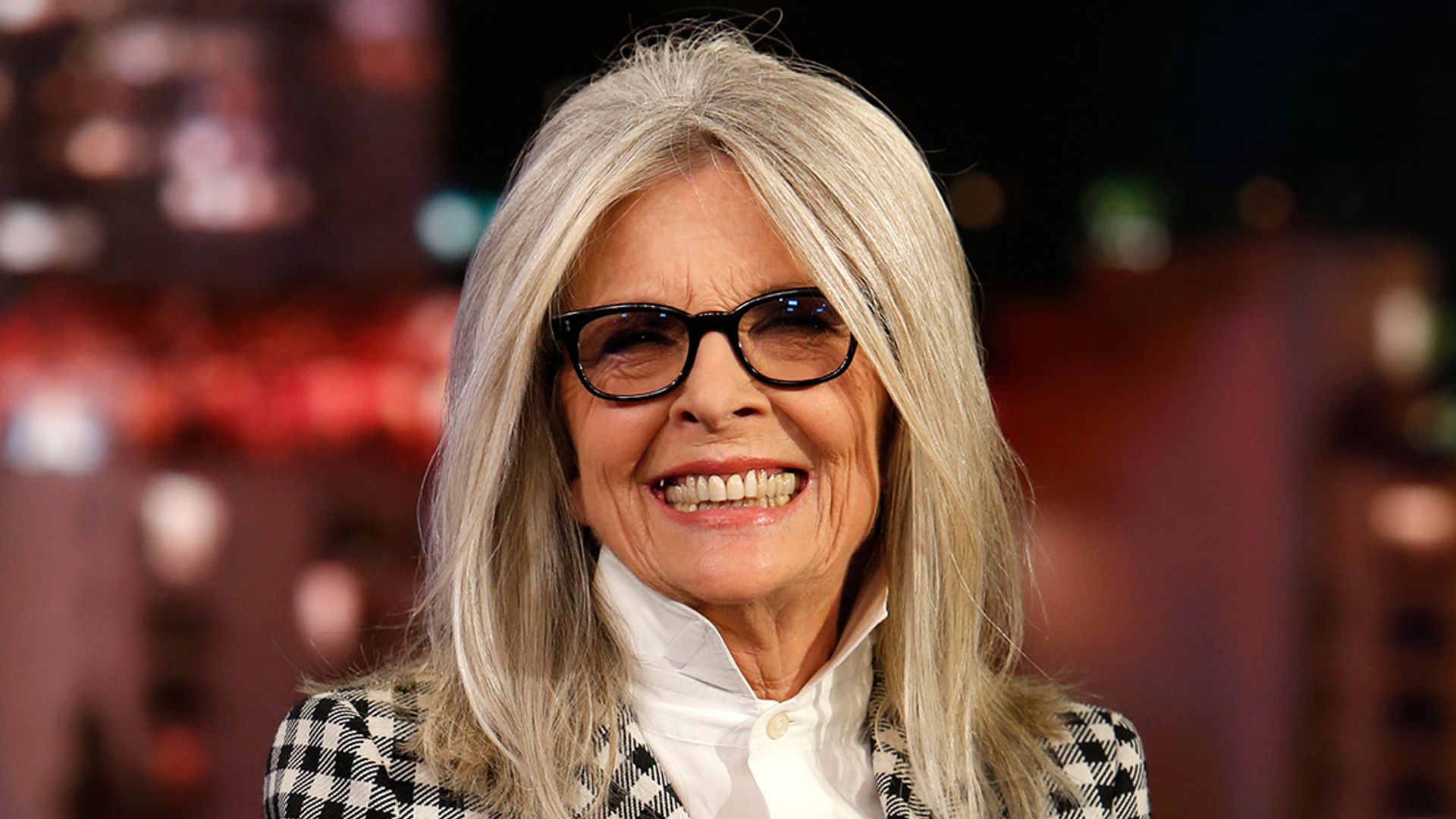 diane keaton smiling sitting on chair