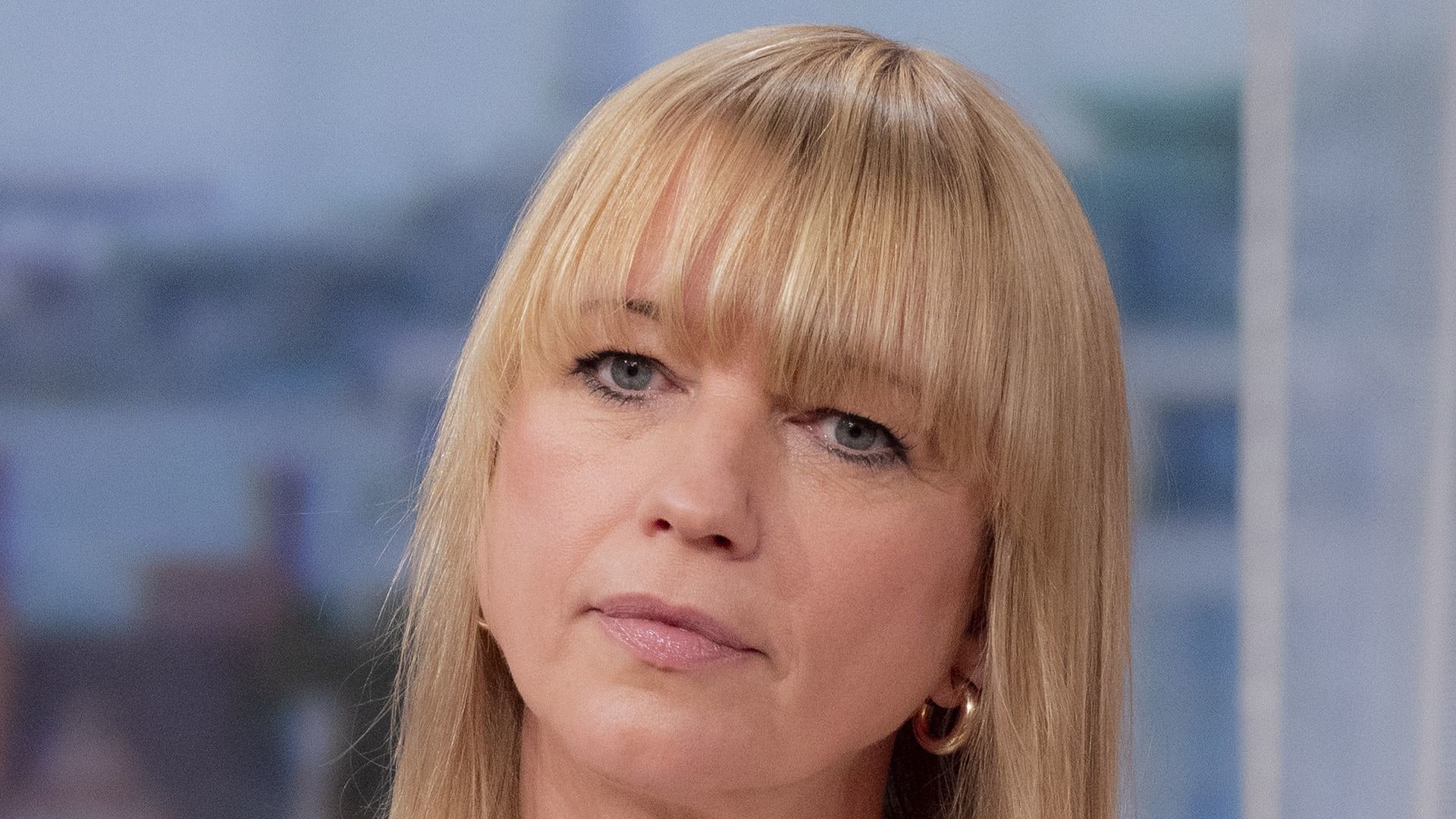 Sara Cox on 'This Morning' with arms crossed in white shirt