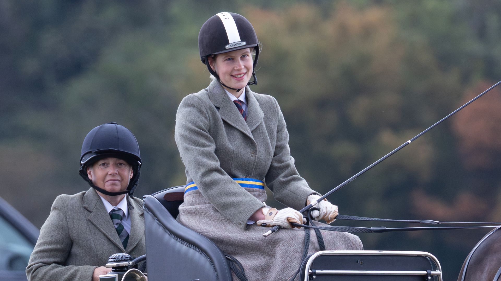 Lady Louise Windsor smiling while driving a carriage