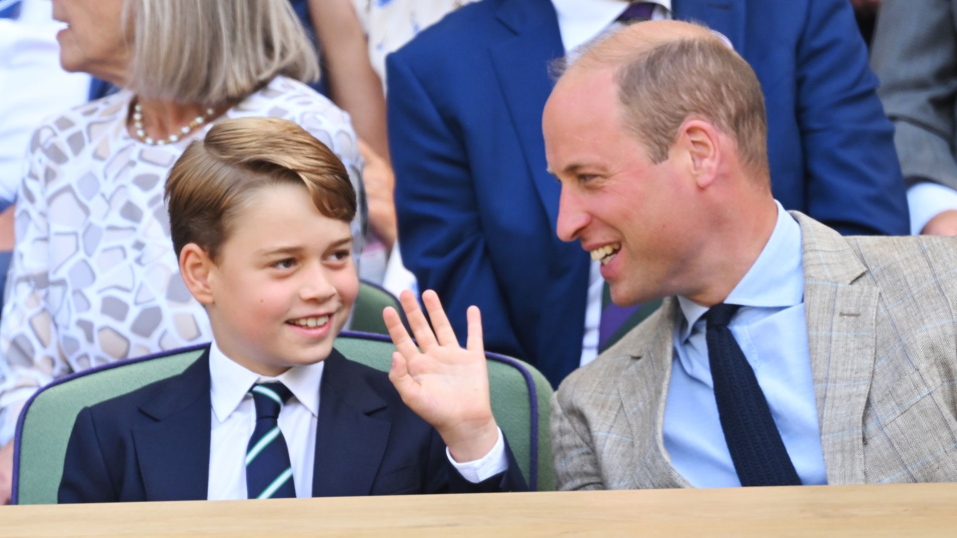 Prince George and Prince William smiling at tennis