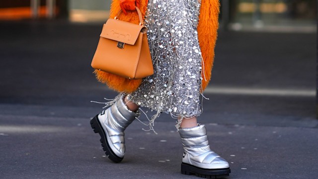 A guest wears a orange fluffy coat, a long silver skirt, a orange bag, sunglasses, silver boots, outside Zimmermann, during the Womenswear Fall/Winter 2024/2025 as part of  Paris Fashion Week on March 04, 2024 in Paris, France. (Photo by Edward Berthelot/Getty Images)