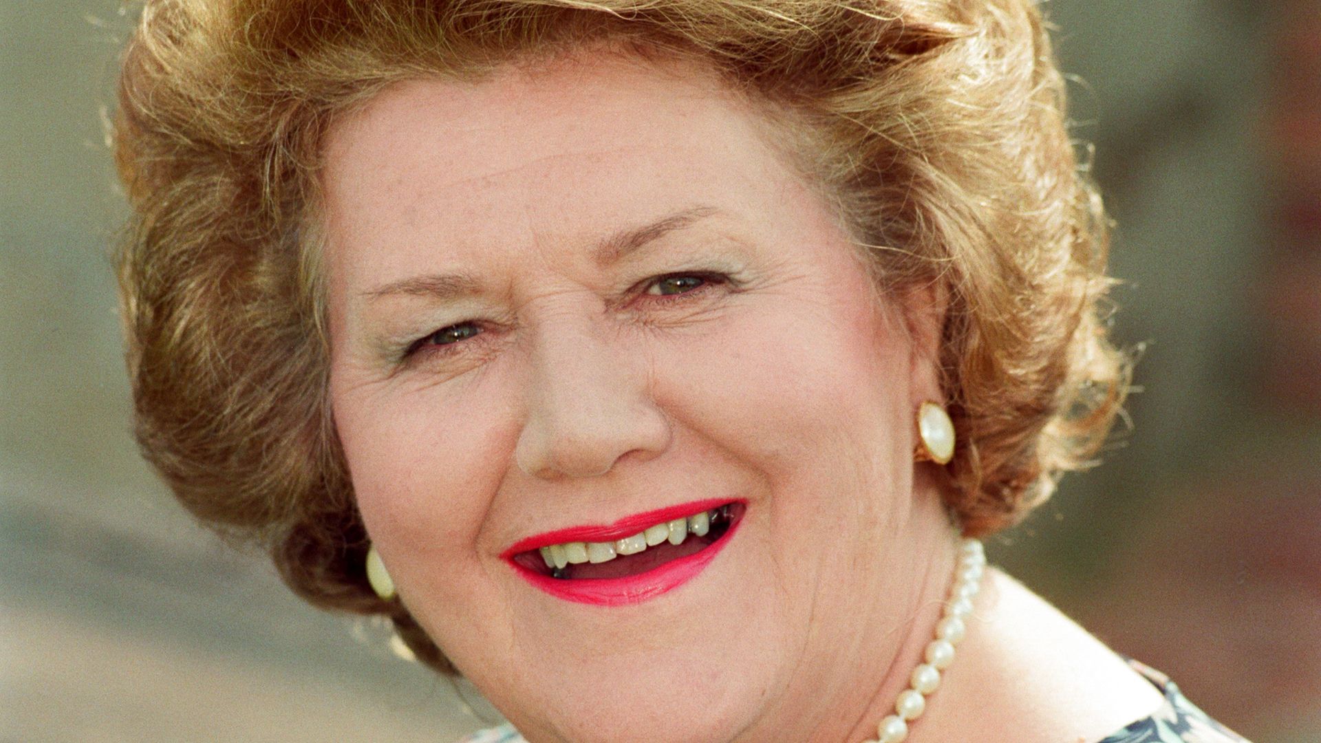 close-up of woman holding pearl necklace