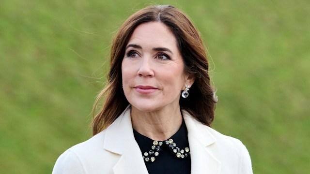 Queen Mary of Denmark looking up in white coat