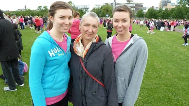 Woman with shaved head with her two daughters