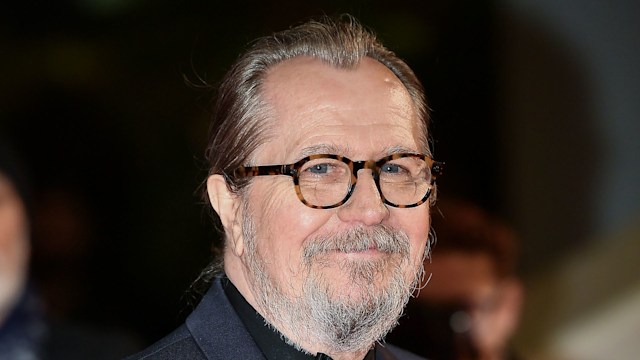 Gary Oldman in a grey suit and glasses