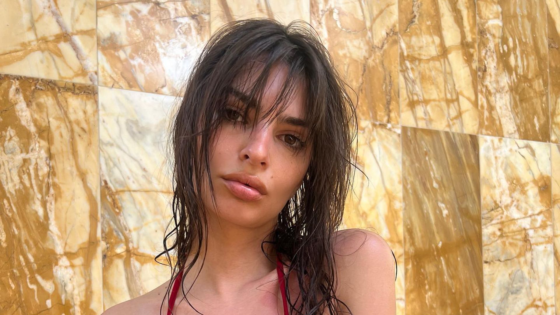 Emily Ratajkowski wears a red bathing suit 