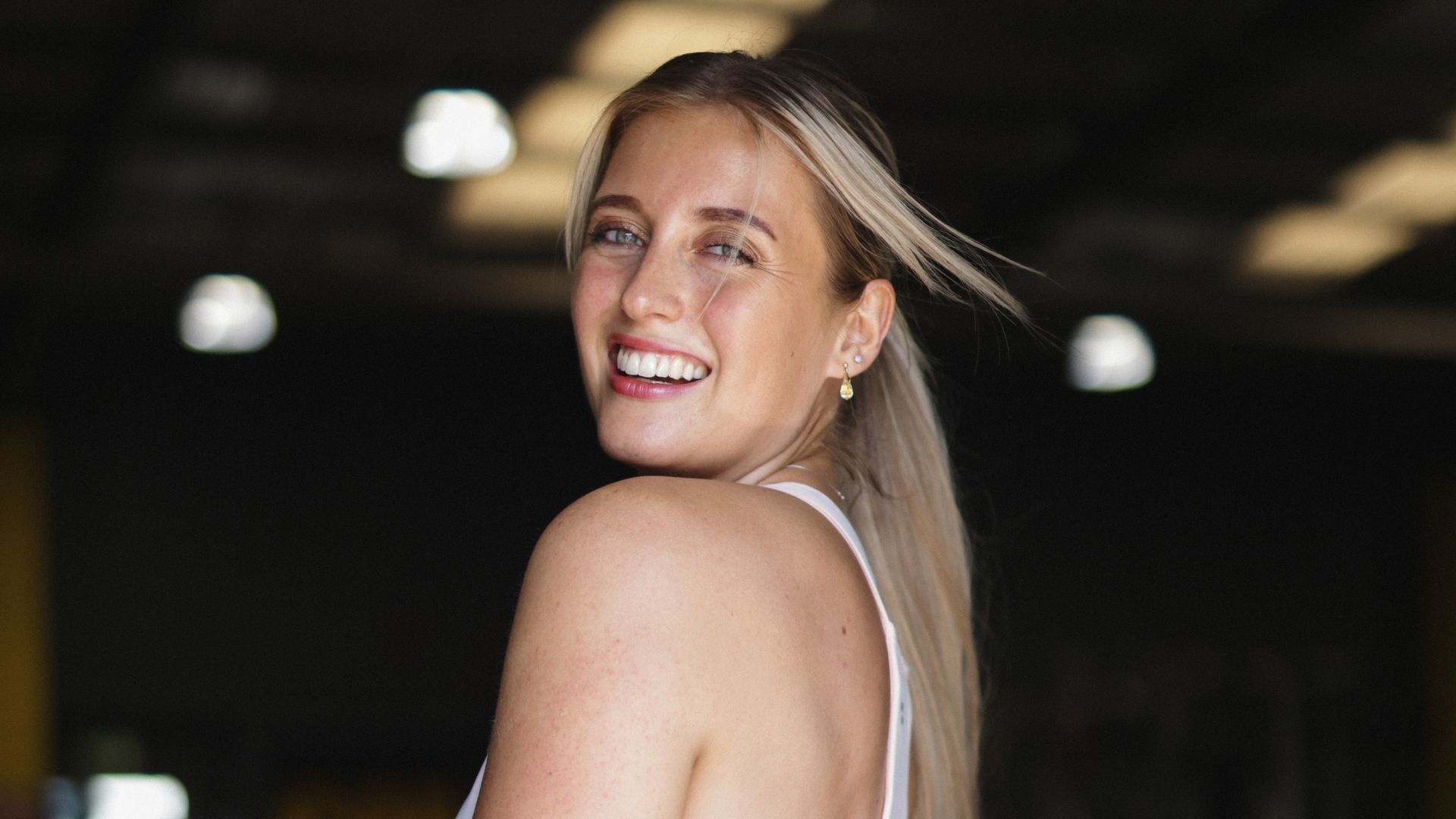 Woman in teal leggings and a white crop top