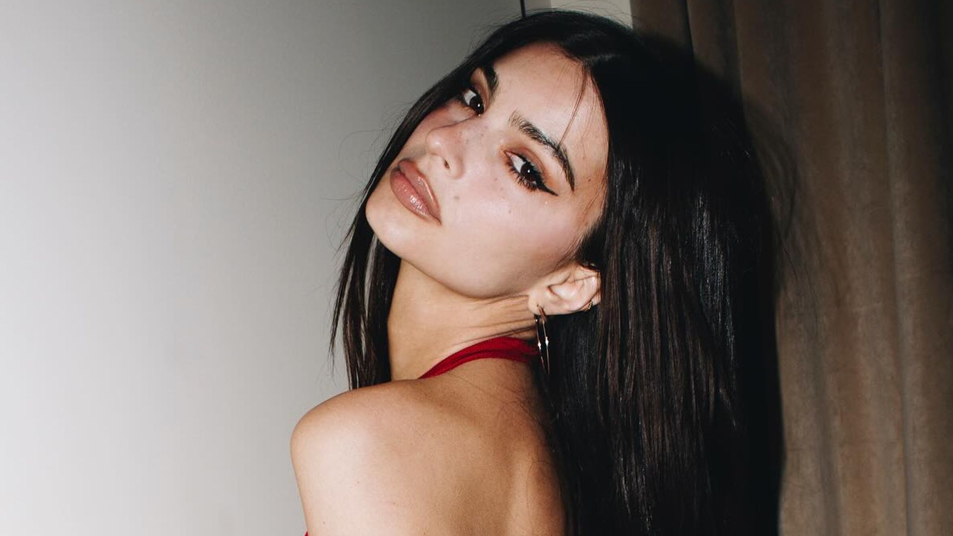 Emily Ratajkowski poses for a photo in a red top