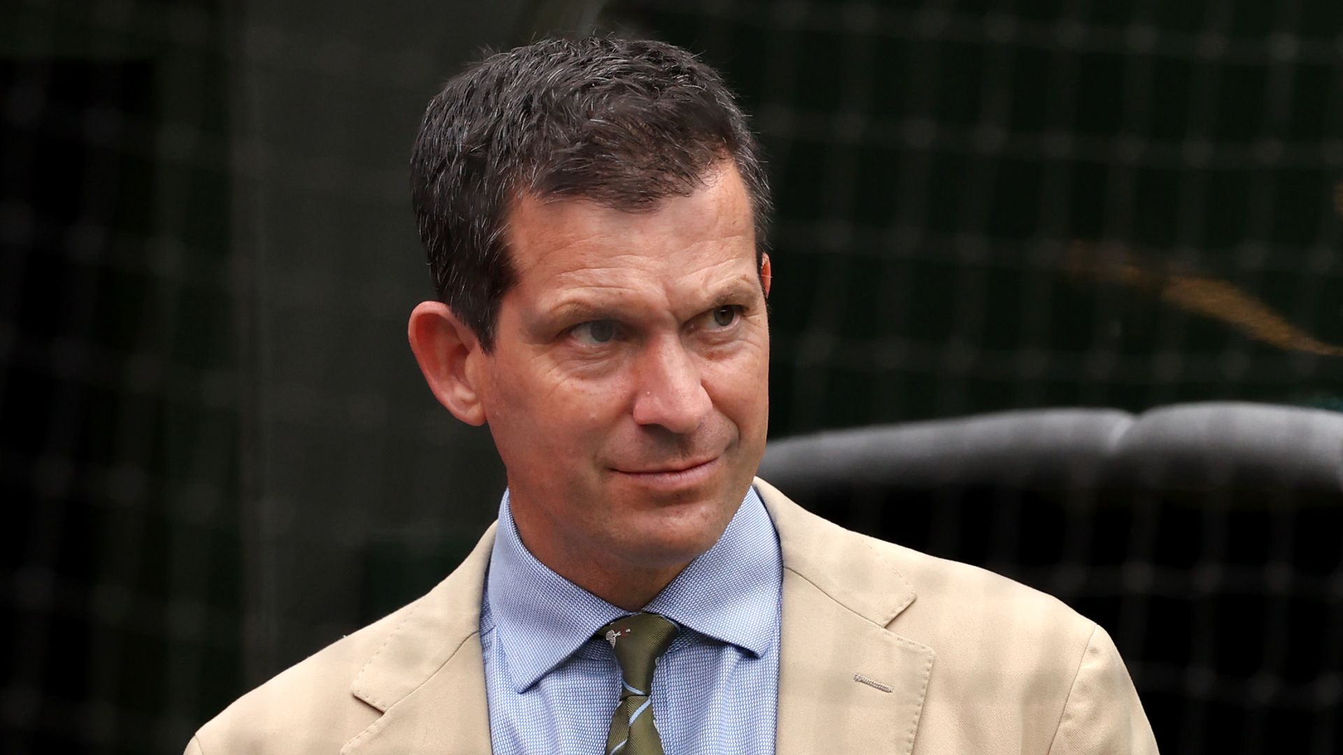 Tim Henman in a tan suit and blue shirt