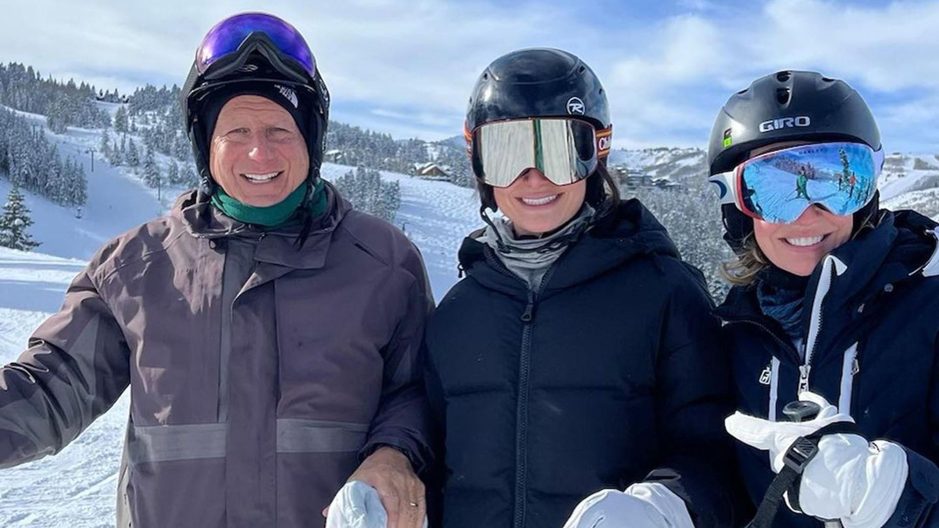 Jennifer, Tom and Chloe smiling in ski gear on a mountain