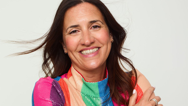 Donna Francis smiling in a rainbow top 