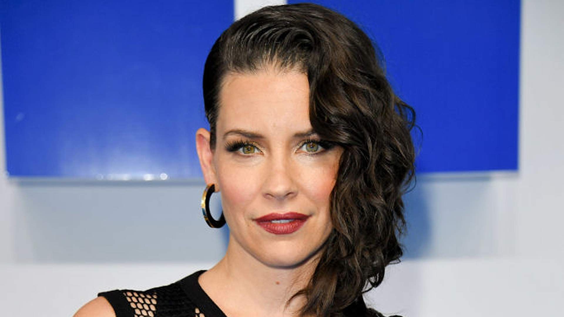 Close-up of Evangeline Lily with her hair styled to one side and red lipstick. 