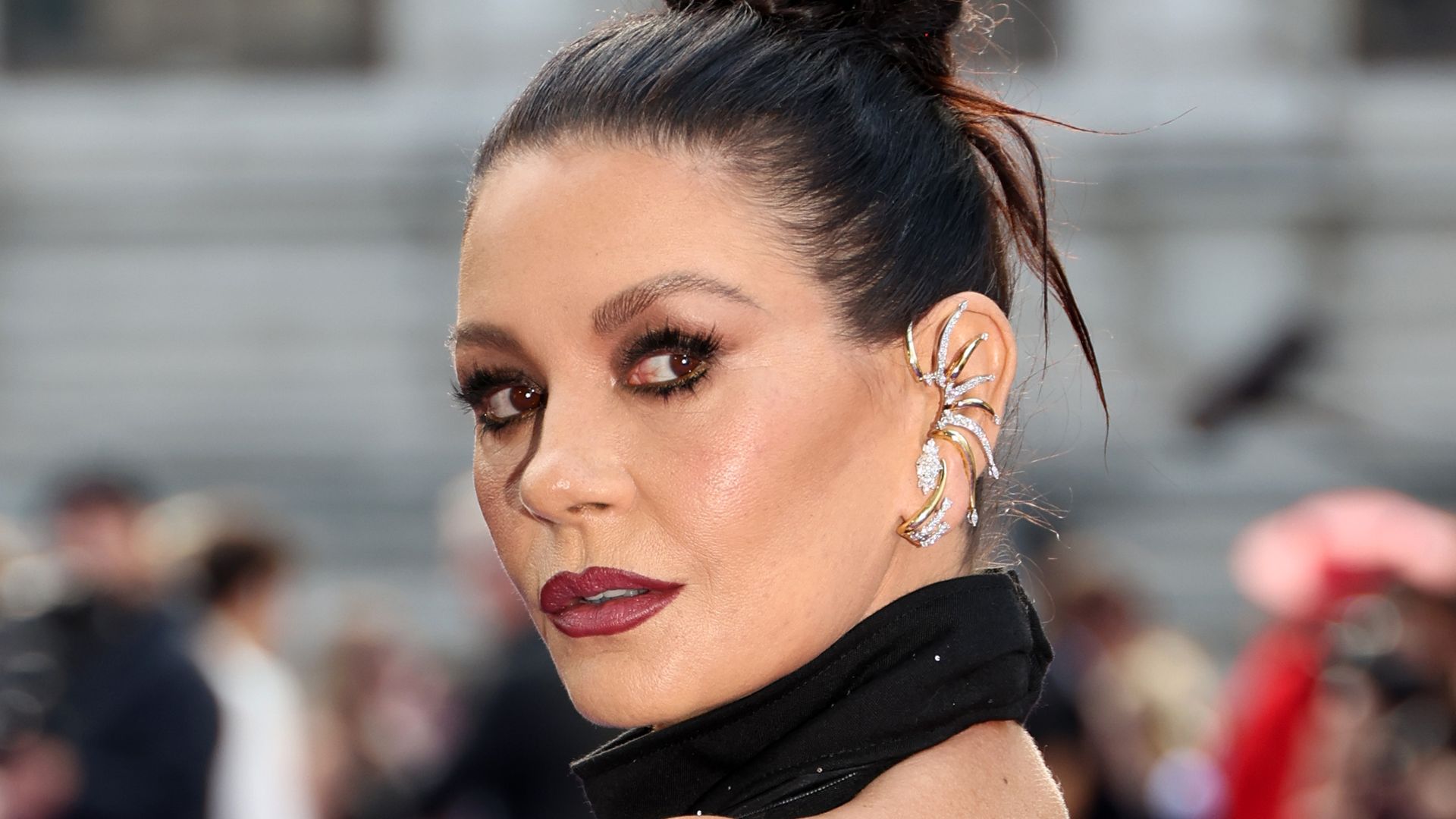 catherine Zeta-Jones on red carpet looking over shoulder in backless gown