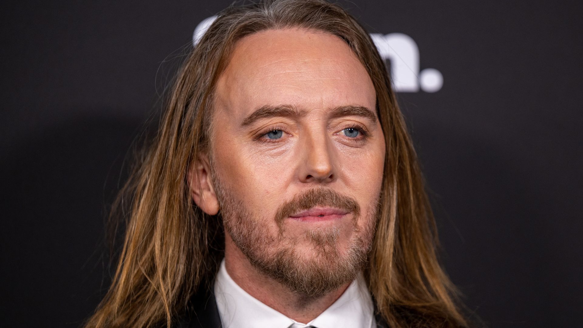 Comedian Tim Minchin in a suit looking at camera as he attends the 22nd Annual G'Day USA Arts Gala at the Skirball Cultural Center on February 21, 2025 in Los Angeles, California. (Photo by Amanda Edwards/Getty Images)