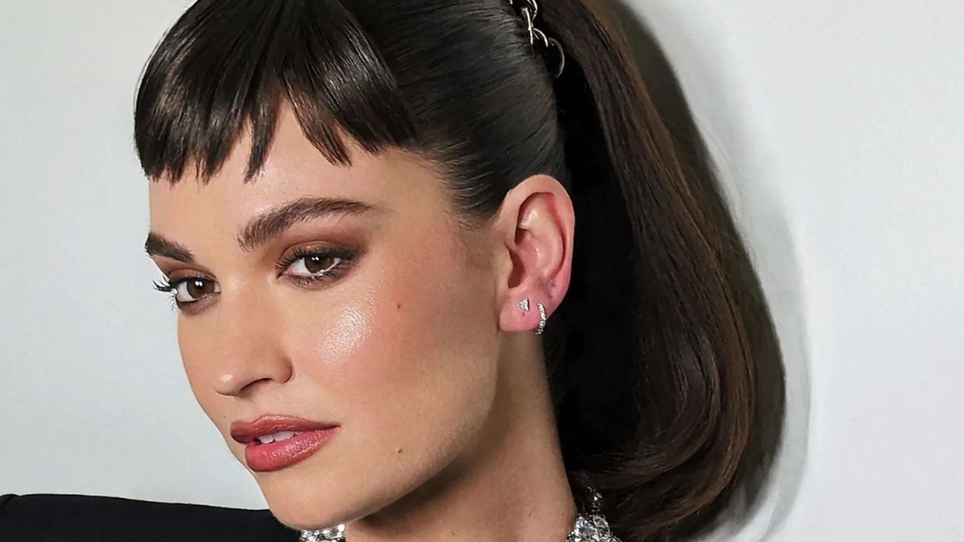 Lily James poses with micro bangs and a diamond necklace at the Met Gala 2023 after party
