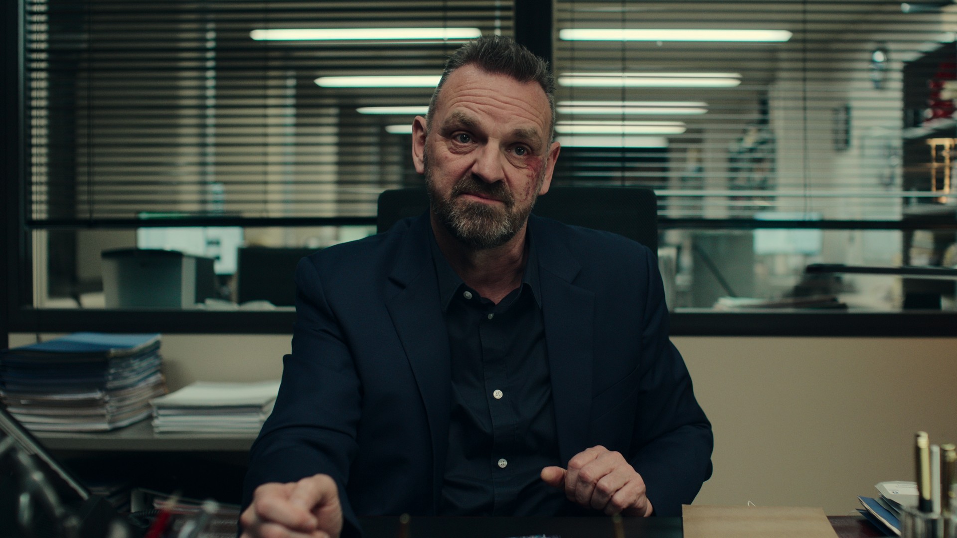 A man sits behind a police desk