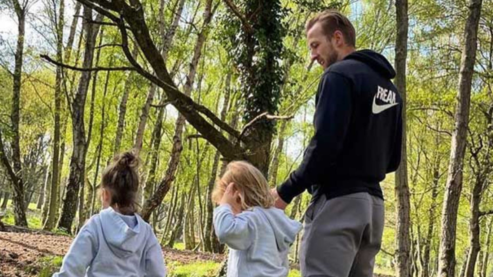 Two young girls and Harry kane walking through the woods