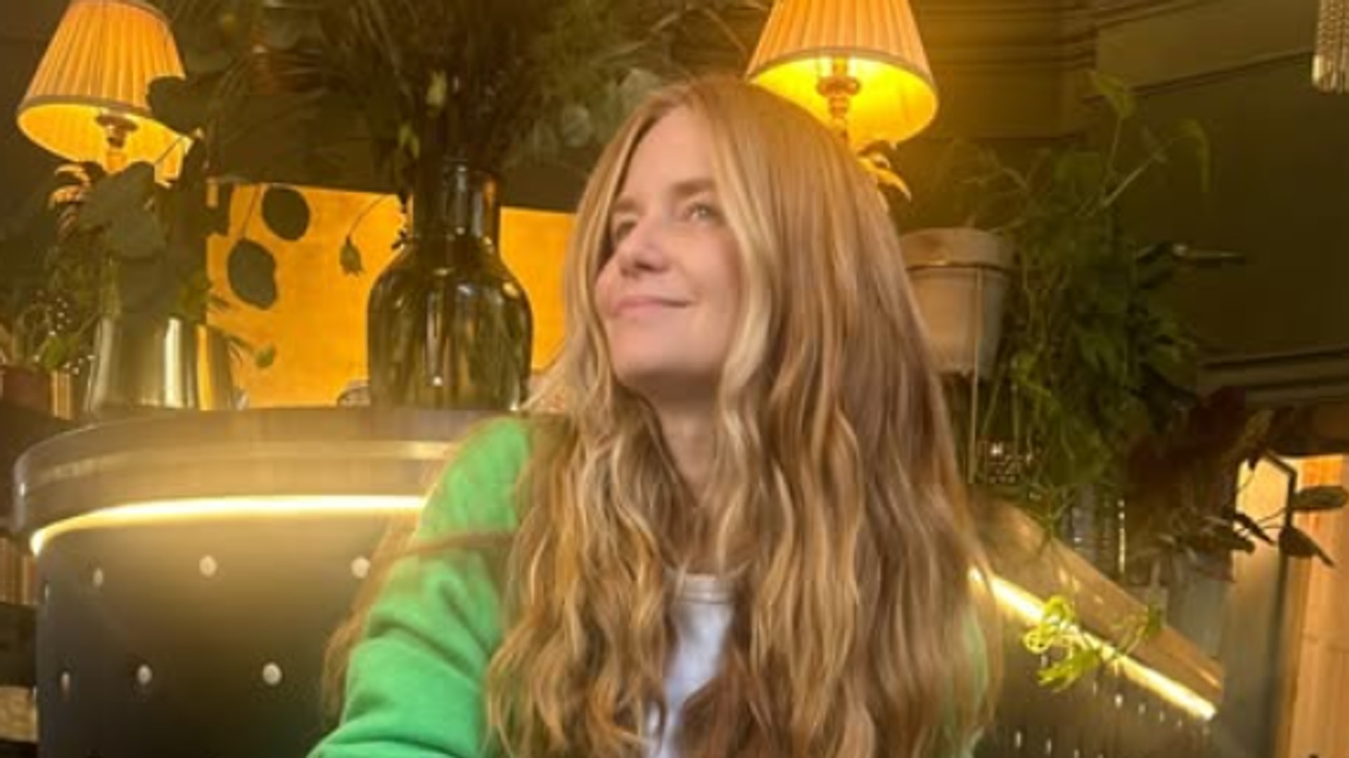 lady with long red hair wearing green shirt 